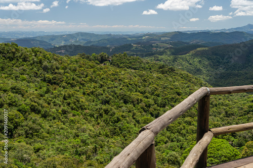 Scenic viewpoint at Chapéu do Bispo hiking trail over lush Atlantic Forest and rolling mountains under summer morning sunny clear blue sky horizon in Monte Verde, Camanducaia, Minas Gerais - Brazil