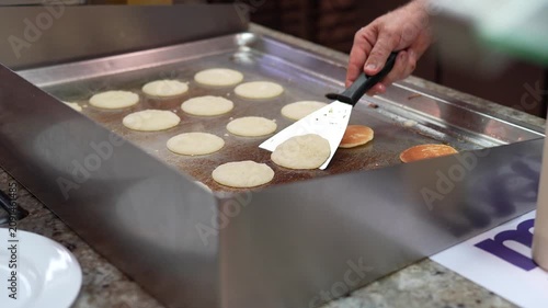 Chef Cooking Mini Pancakes on Hot Griddle Close Up