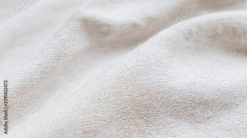 soft white cotton knit fabric texture in macro close up revealing gentle folds and cozy sustainable aesthetic