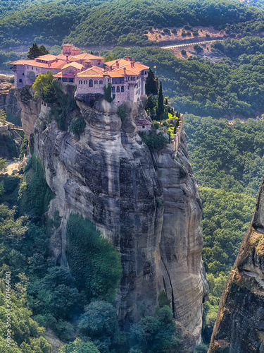Kalambaka, Greece - July 24, 2024: Holy Monastery of the Great Meteoron, Meteora, looking down at Saint Stephen's Monastery from the rock plateau. Mountain range on the horizon.