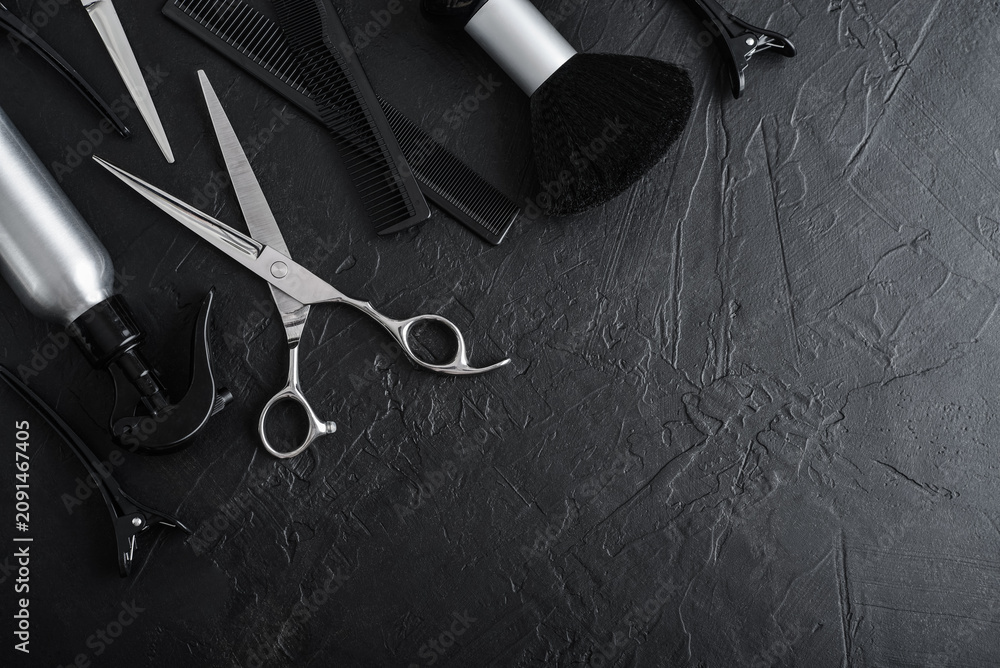Obraz premium Professional hairdresser tools on a black textured concrete background.