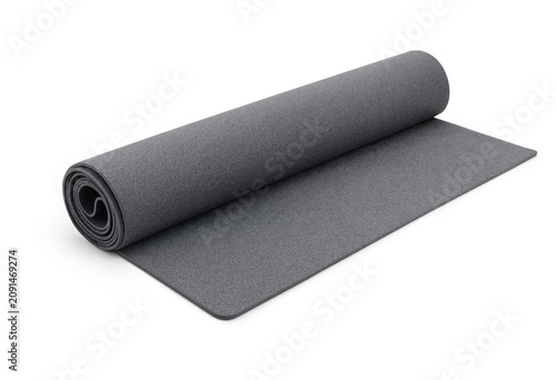 Grey rubber fitness mat partially rolled on white background with exercise stretching training equipment