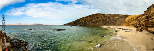 Peru, South America: breathtaking aerial and panoramic view of Playa La Mina (Mine Beach), hidden gem in the Paracas National Reserve famous for crystal-clear turquoise waters, white sand and cliffs