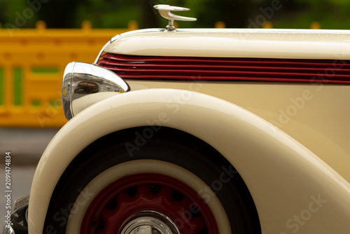 Фотография Detailed close view of a classic cream-colored automobile showing the curved fro