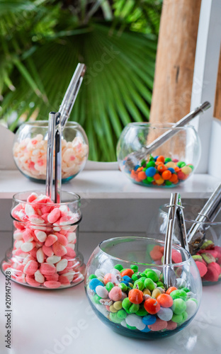Mesa de dulces con frascos de vidrio llenos de caramelos y golosinas para celebración o evento