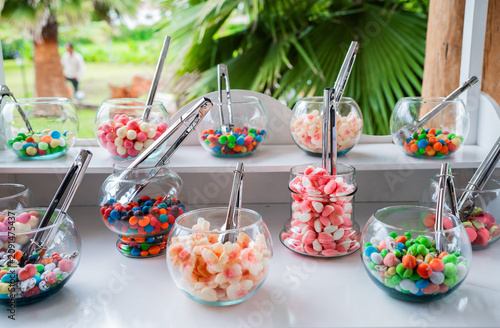 Obraz na plátne Mesa de dulces con frascos de vidrio y variedad de caramelos de colores para bod