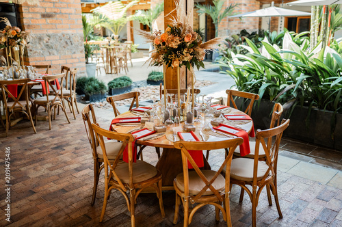 Foto Mesa elegante para evento con decoración floral y montaje rústico en espacio al