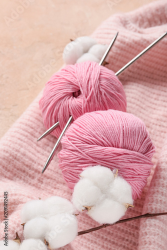 Canvastavla Pink yarn balls with knitting needles and cotton bolls on a soft knitted fabric