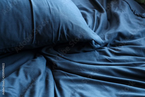 Fotografie Cozy bed with soft pillow and black bedclothes, closeup
