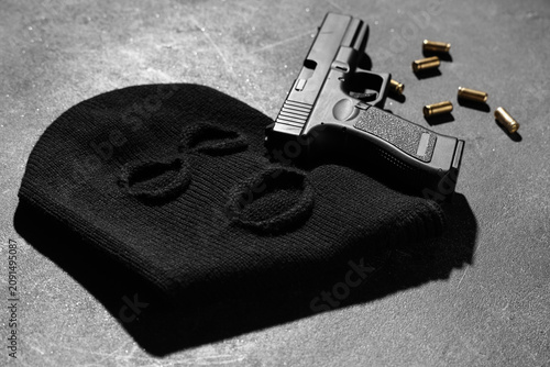 Photos Balaclava with gun and bullets on dark background