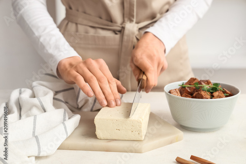 Woman cutting tofu cheese o...