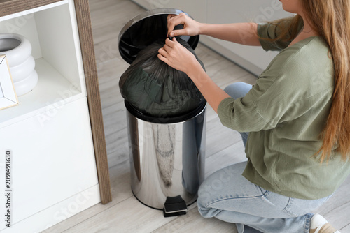 Woman throwing full garbage...