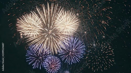Bright golden fireworks exploding in the dark night sky during a celebration