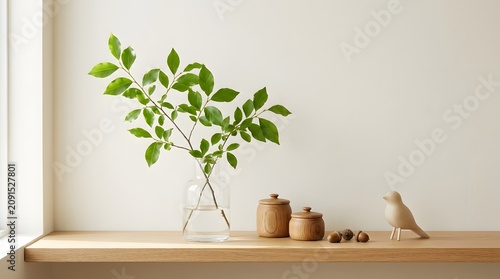 Minimalist Interior Decor on Wooden Shelf with Green Branch in Glass Vase and Wooden Accessories