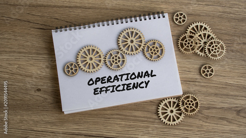 Operational efficiency concept with handwritten text on notebook and wooden gears on office desk