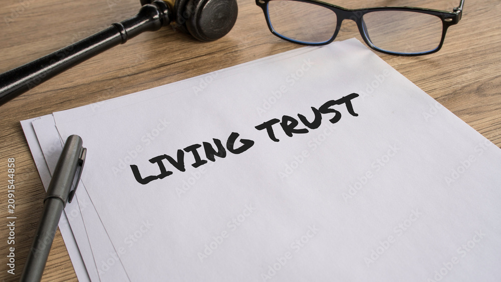 Naklejka premium Living Trust legal document on wooden desk with gavel and glasses