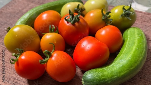 Schilderij op canvas Fresh colorful cherry tomatoes in different stages of ripeness arranged on a rustic wooden background