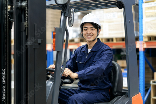 笑顔でフォークリフトを運転する作業員