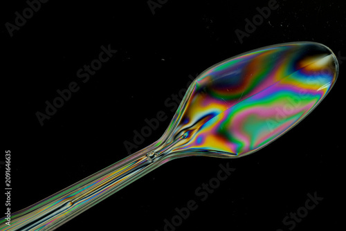 Fotografía Plastic fork and spoon photographed with polarized light creating colourful stre