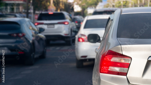Fotografie Rear view shot of a silver car's red tail light waiting in heavy traffic