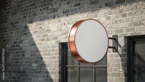 Elegant circular blank copper sign mounted on rustic textured brick wall