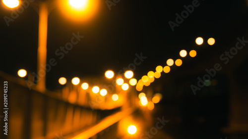 Fotografie Abstract night city lights with golden bokeh and blurred street lamps along urban bridge