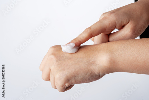 Fotografie Woman gently rubbing lotion into hands extra nourishment.