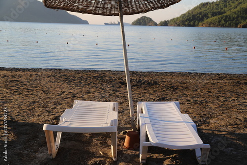Fotografía Sun loungers overlooking the calm sea in a mountainous cove