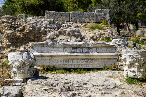 Ancient Roman ruins with inscription mentioning Caesar and Antoninus Pius, likely from a temple or public building, possibly in Turkey.