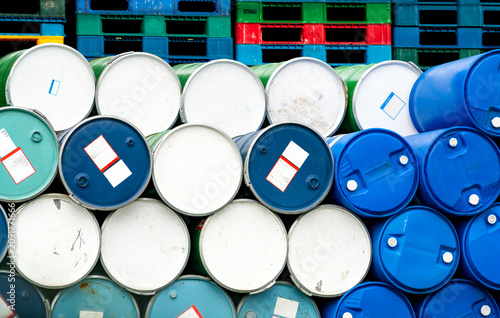 Bild auf Leinwand Old chemical barrels in front of stacked plastic pallet at the factory