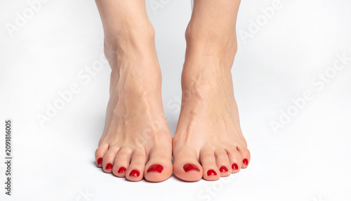 Woman's legs with red pedicure isolated on white background. Feet and heels