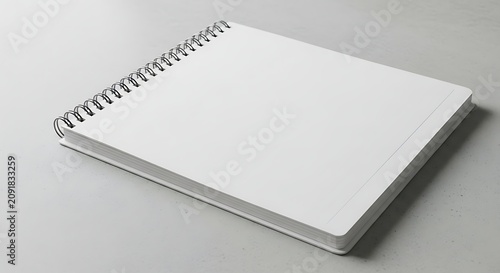 Blank White Spiral Notebook Resting on Minimal Gray Surface
