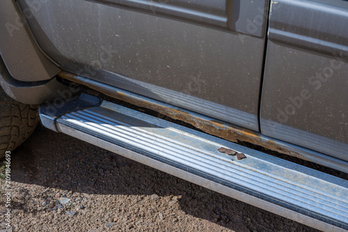 Foto Close-up of rust and corrosion on the side step and rocker panel of an SUV