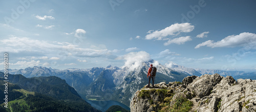 Tableau sur toile Wanderer auf einem Fels blickt auf Berge