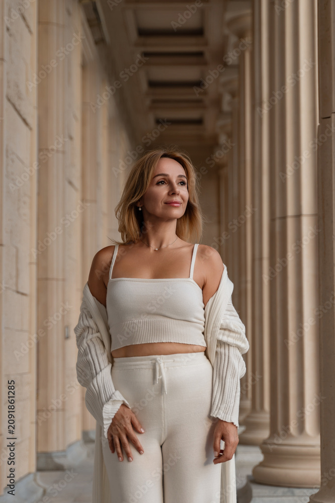 Fototapeta premium Woman White Outfit Columns Building Fashion