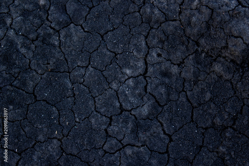 Canvas Print Moody low key texture of dry cracked black soil, detailed dark ground background