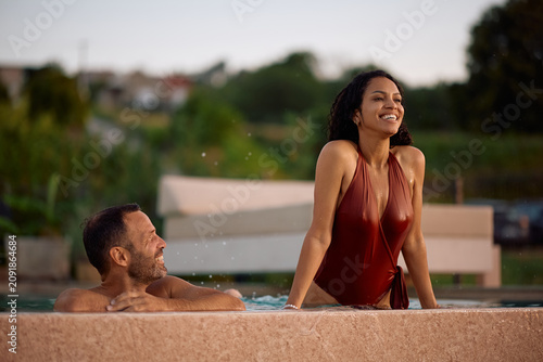 Photos Carefree couple enjoying in resort swimming pool in summer.