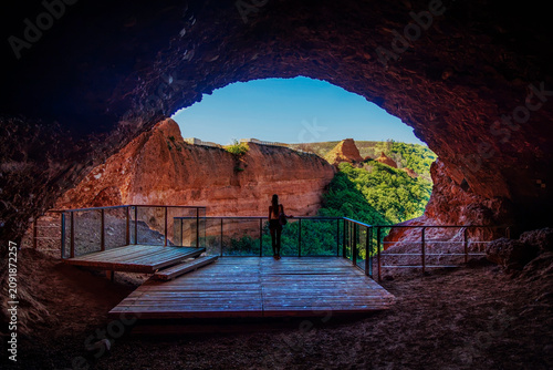 Tableau sur toile silhouette of hiker standing on observation deck inside cave looking at ancient