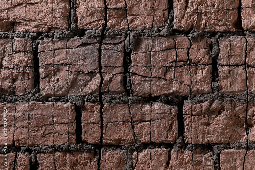 Fototapeta premium Weathered dark red brick wall background with deep cracks