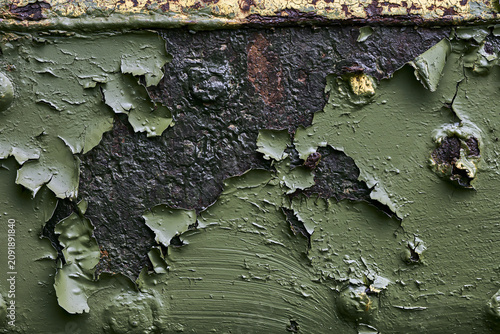 Flaking dark green paint on a rusty metal surface close up abstract texture