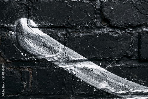 White spray paint brush stroke on black brick wall texture