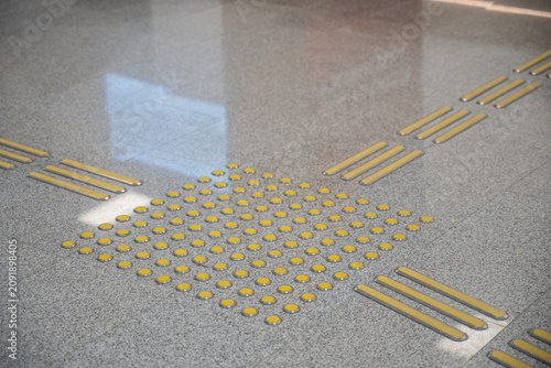 Schilderij op canvas Intersection of tactile yellow tiles. Braille.