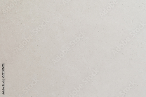 Close-up of smooth light grey polished concrete wall texture with small pores