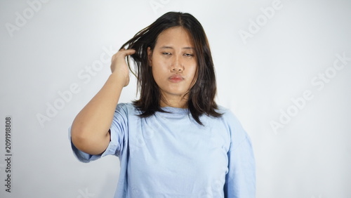 Foto Young Woman with Tangled Hair Looking Confused Against White Background