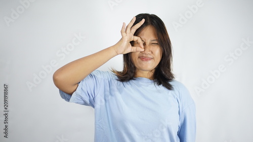 Cuadro en lienzo Woman making OK sign over eye, expressing positive feeling, white background