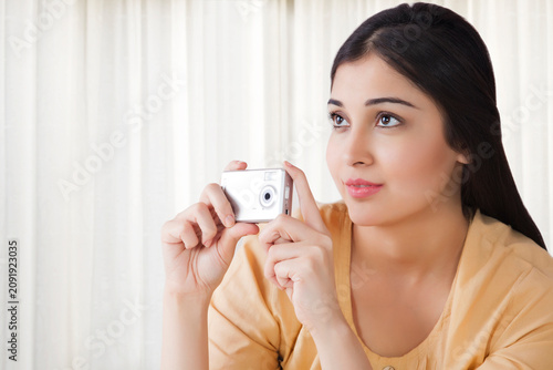 Canvas Print Young woman taking a photograph with camera
