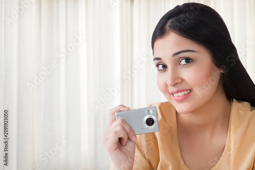 Photography Young woman taking a photograph with camera