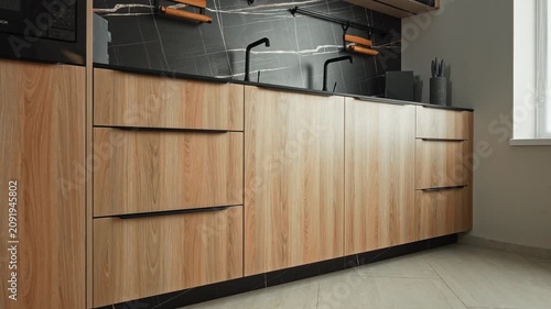 Chic Light Wood Cabinets Featuring Integrated Appliances And Sophisticated Marble Backsplash