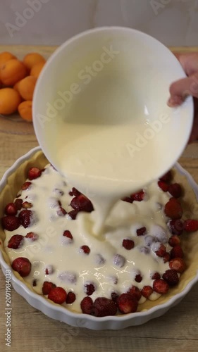 The process of pouring the filling into a strawberry pie