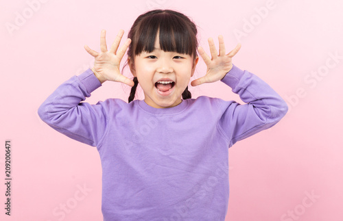 Obraz na płótnie A funny little girl making a silly face and grimacing playfully towards the camera